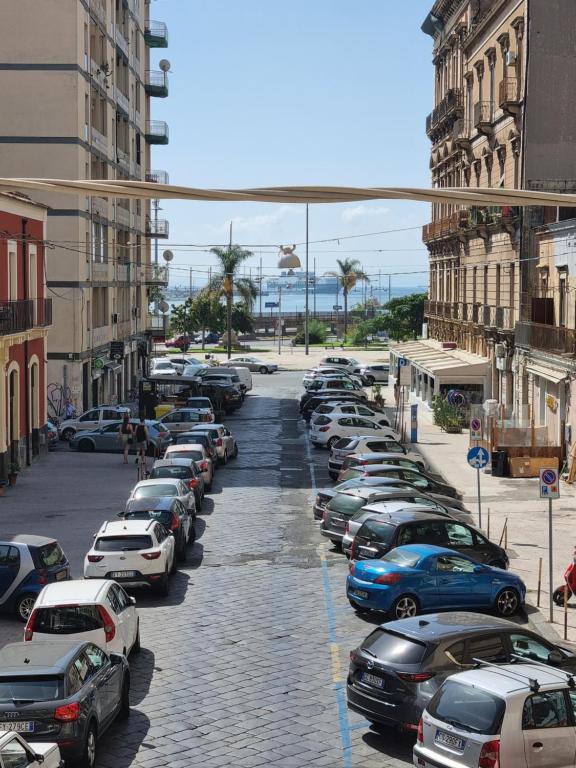 uma rua cheia de carros estacionados numa cidade em Happy Home em Catânia