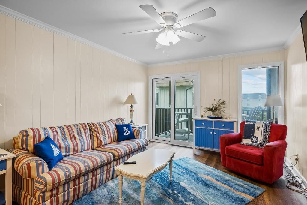 een woonkamer met een bank en een rode stoel bij Southwinds C8 in Atlantic Beach