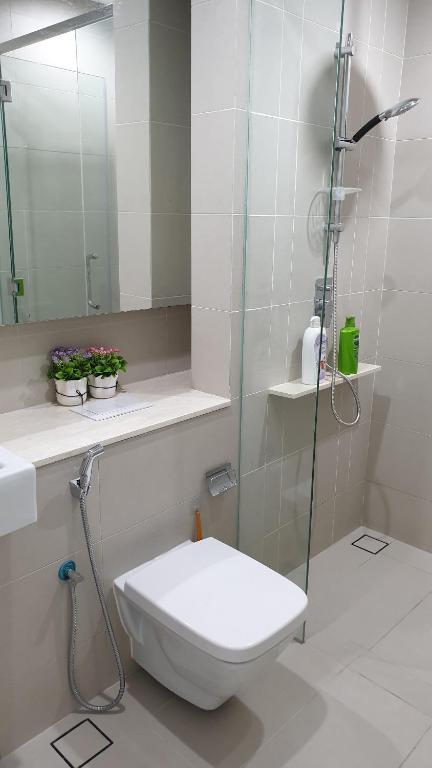 La salle de bains est pourvue de toilettes et d'une douche en verre. dans l'établissement Studio at The Ridge KL East W, à Kuala Lumpur