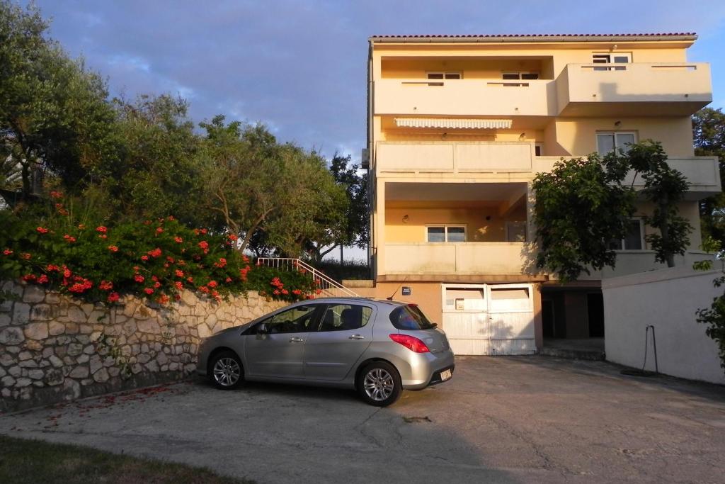 ein kleines silbernes Auto, das vor einem Gebäude parkt in der Unterkunft Apartments by the sea Kampor, Rab - 18268 in Rab