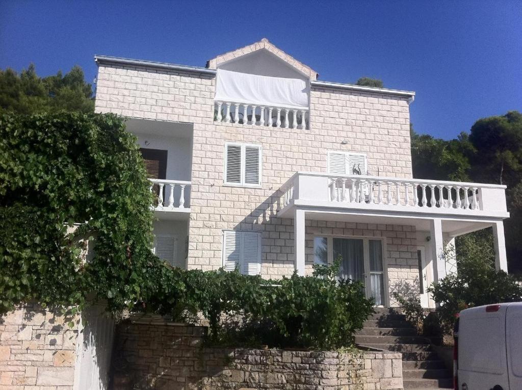 ein großes weißes Backsteinhaus mit Balkon in der Unterkunft Apartments by the sea Brna, Korcula - 18288 in Smokvica