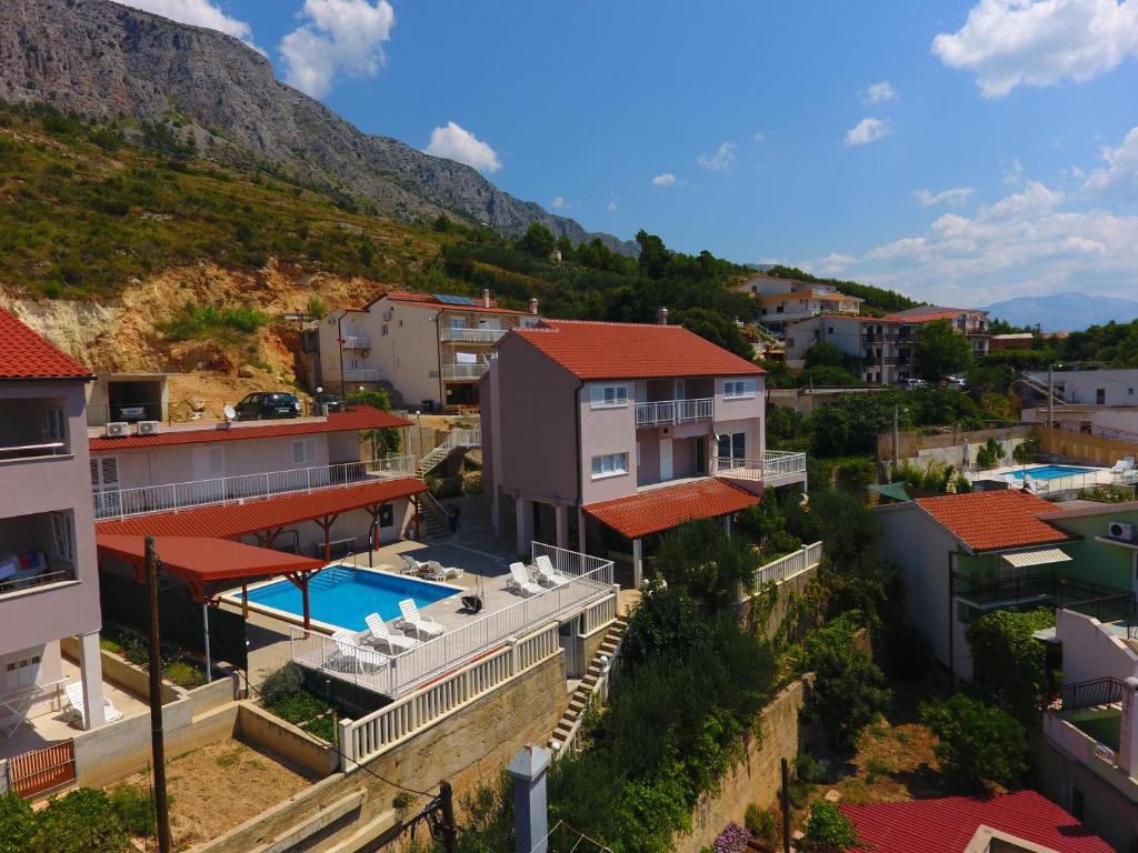 a house with a swimming pool and a mountain at Apartments and rooms with a swimming pool Lokva Rogoznica, Omis - 18328 in Lokva Rogoznica