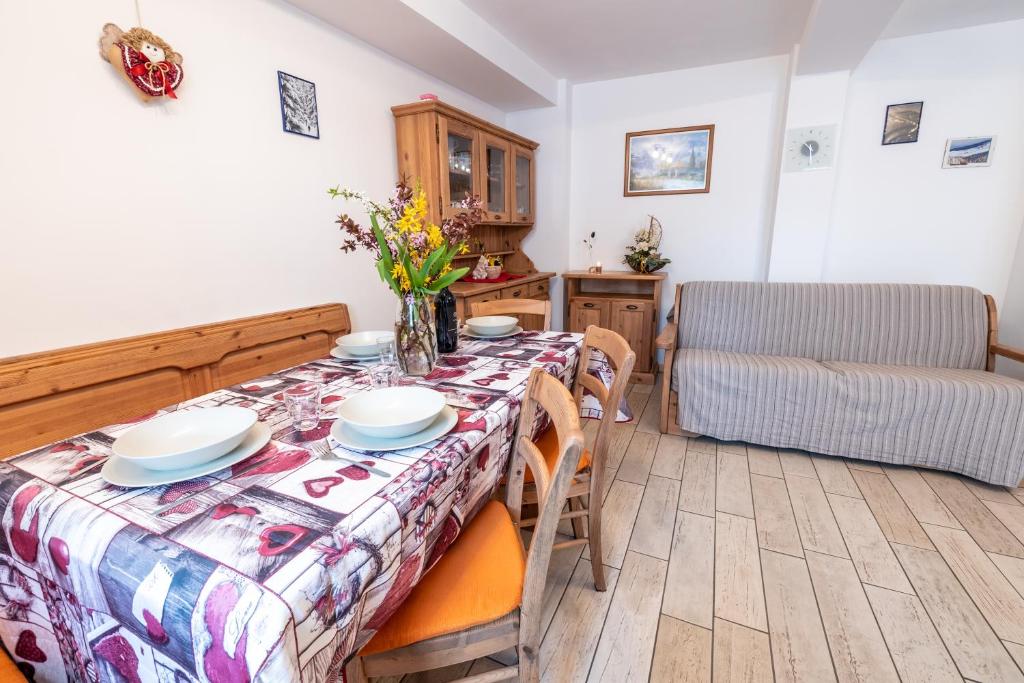 a dining room with a table and a couch at Casa Pergher in Folgaria