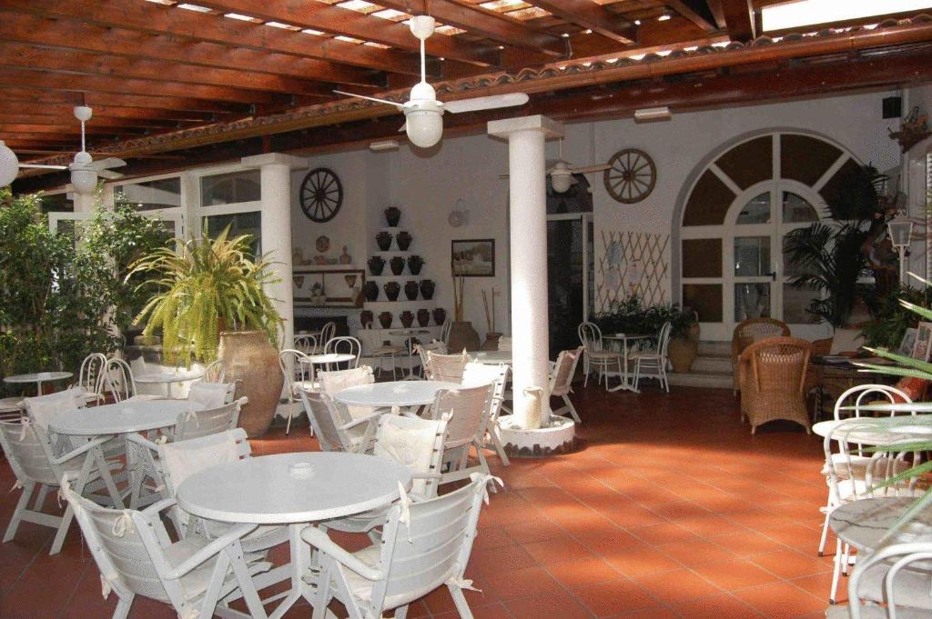 
a patio area with tables, chairs and umbrellas at Hotel Villa Augustus in Lipari
