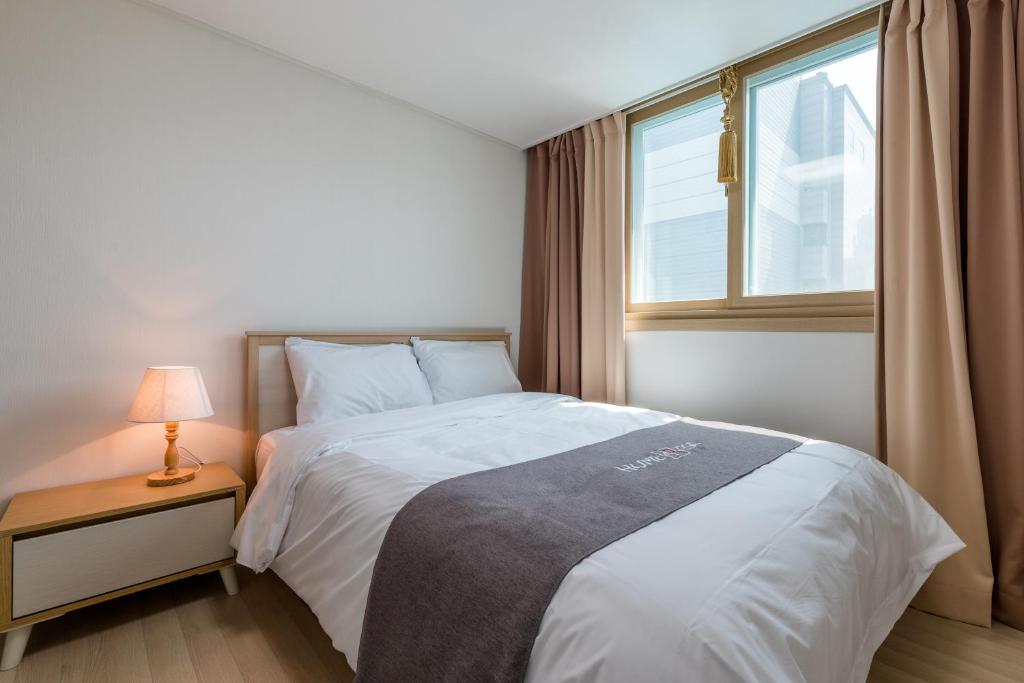 Postel nebo postele na pokoji v ubytování JS Residence Hotel Okpo