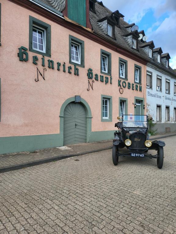 un coche viejo estacionado frente a un edificio en Gastehaus in der Alte Kellerei en Kobern-Gondorf