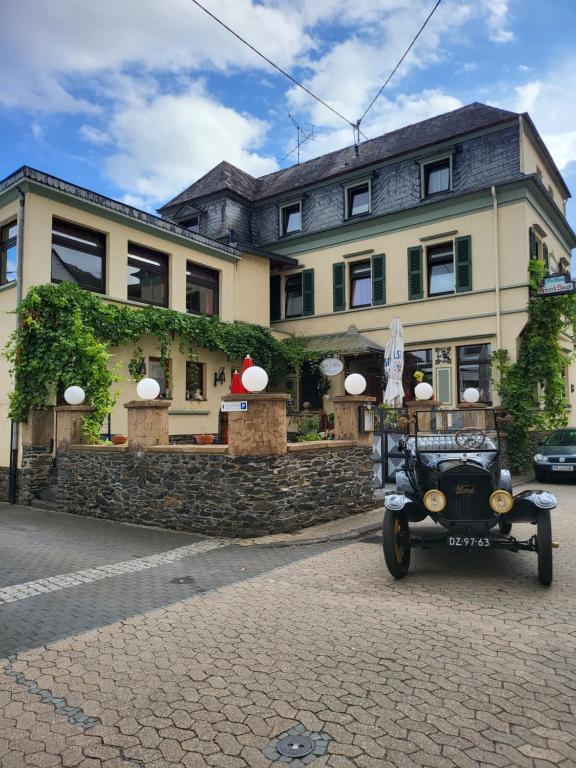 um carro velho estacionado em frente a um edifício em Hotel Haupt em Kobern-Gondorf