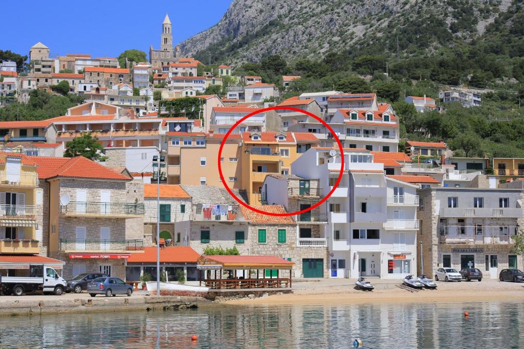 a group of buildings in a city with a red circle at Apartments by the sea Igrane, Makarska - 18405 in Igrane