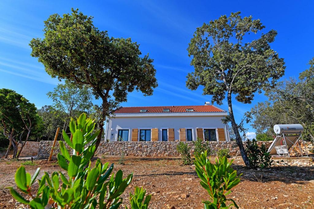 a white house with trees in front of it at Secluded fisherman's cottage Paklinski Islands - Paklinski otoci, Hvar - 18411 in Hvar