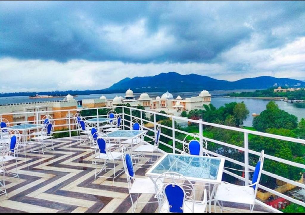 a balcony with tables and chairs on a cruise ship at Royal Rafahiya Haveli - LAKE FACING in Udaipur