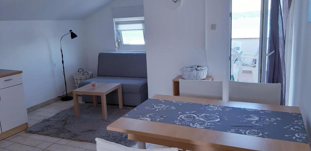 a small living room with a table and a couch at Apartments by the sea Nevidjane, Pasman - 18427 in Neviđane