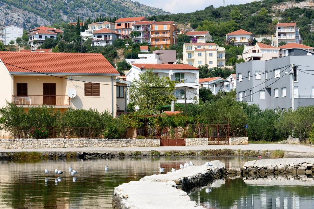 una ciudad con edificios y patos en el agua en Apartments by the sea Seget Vranjica, Trogir - 18229, en Seget Vranjica