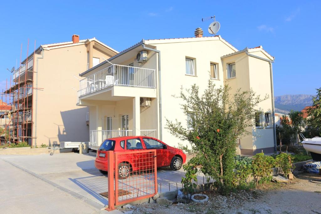 a red car parked in front of a house at Apartments with a parking space Split - 18214 in Solin