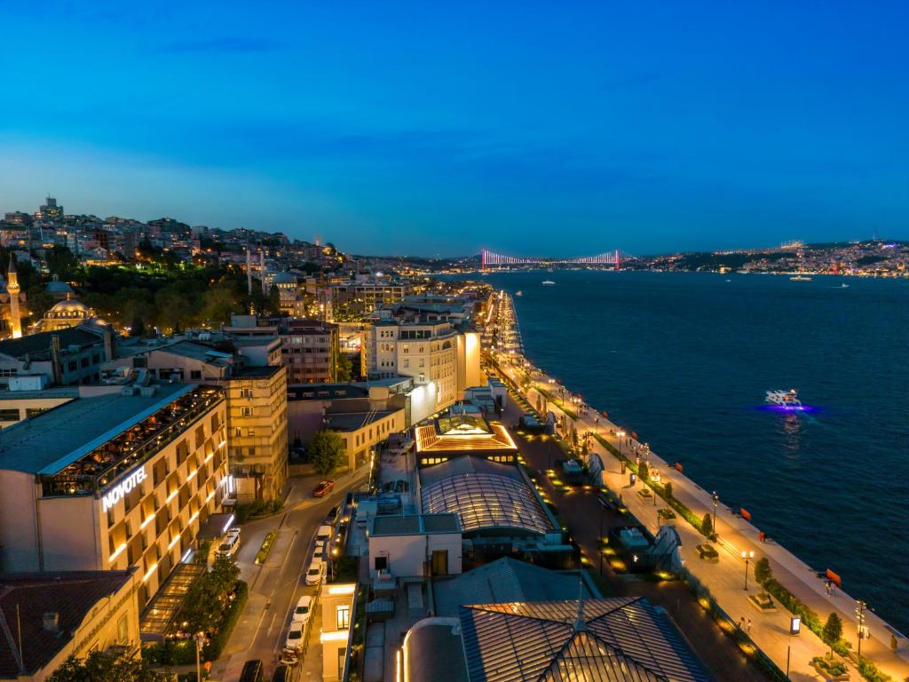 a view of a city at night with a bridge at Novotel Istanbul Bosphorus Hotel in Istanbul