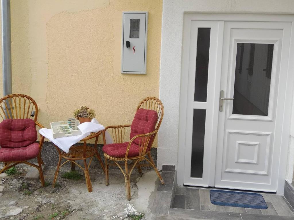 stół z 2 krzesłami i stół z książką w obiekcie Apartments by the sea Sibenik - 18501 w Szybeniku