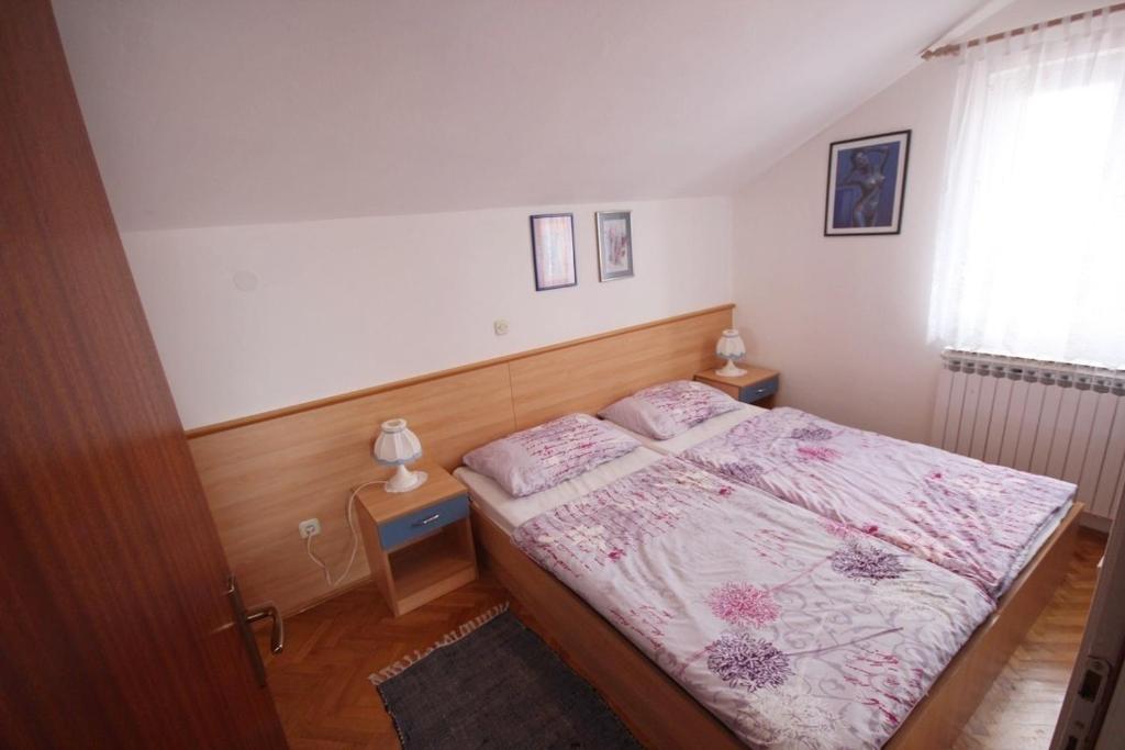 sypialnia z łóżkiem i 2 szafkami nocnymi w obiekcie Apartments by the sea Vir - 18514 w mieście Vir