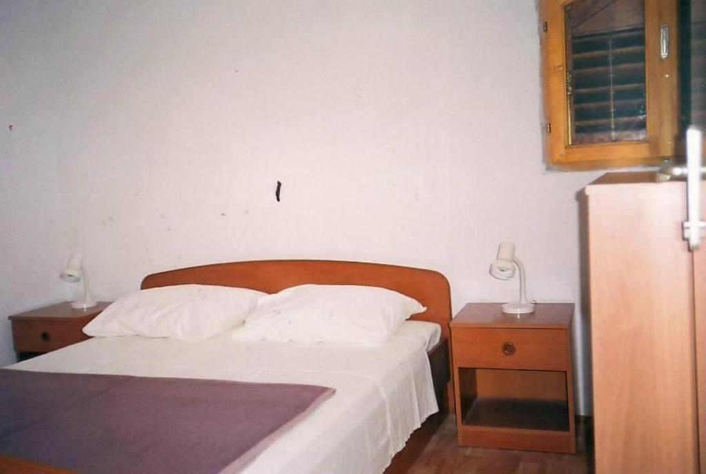 a bedroom with a bed with two night stands and a refrigerator at Apartments by the sea Srima - Vodice, Vodice - 18470 in Vodice