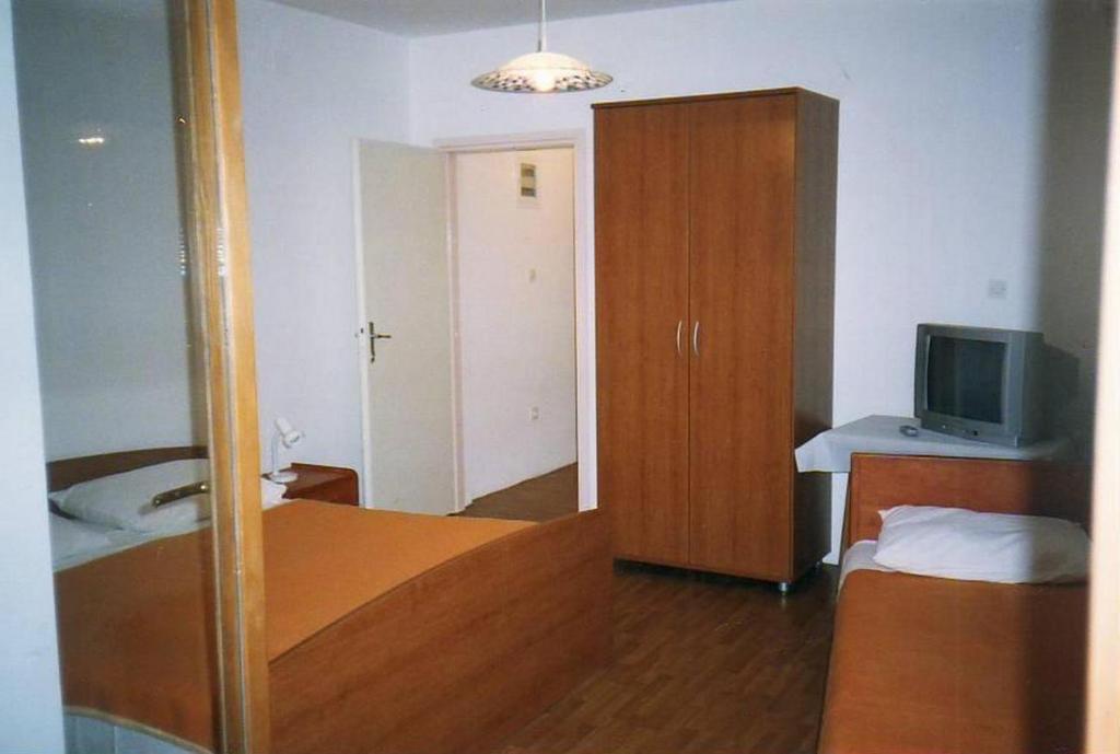 a bedroom with a bed and a cabinet and a television at Apartments by the sea Srima - Vodice, Vodice - 18470 in Vodice
