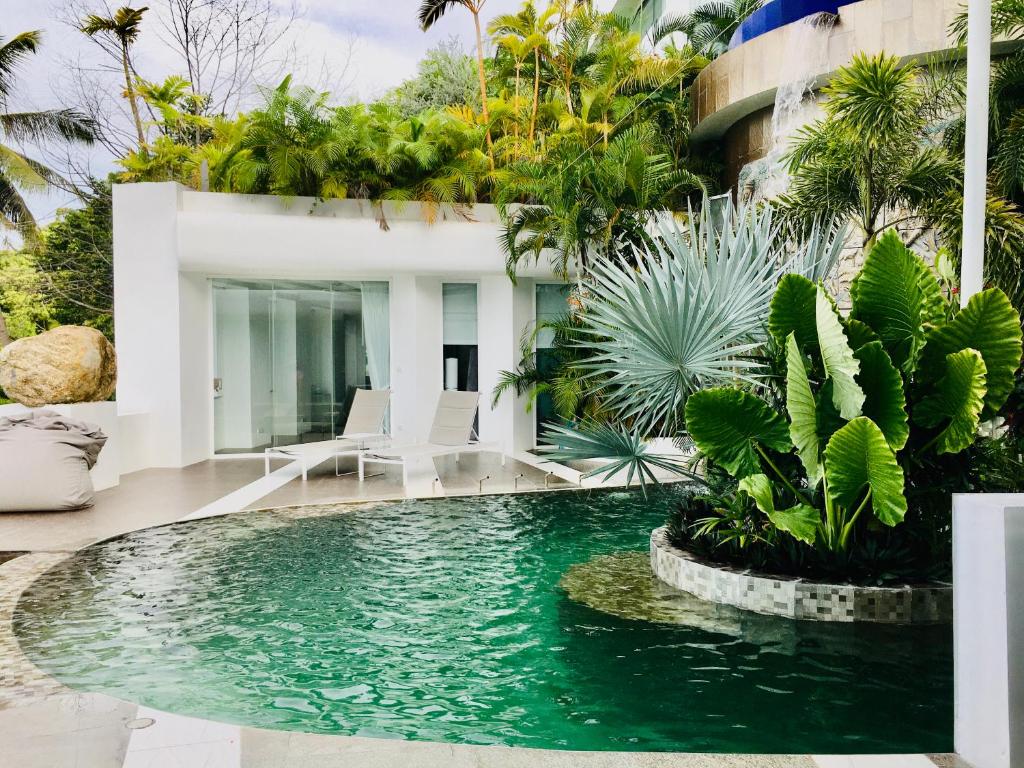 a swimming pool in front of a house with plants at Samui Sky Pool Villa in Koh Samui 