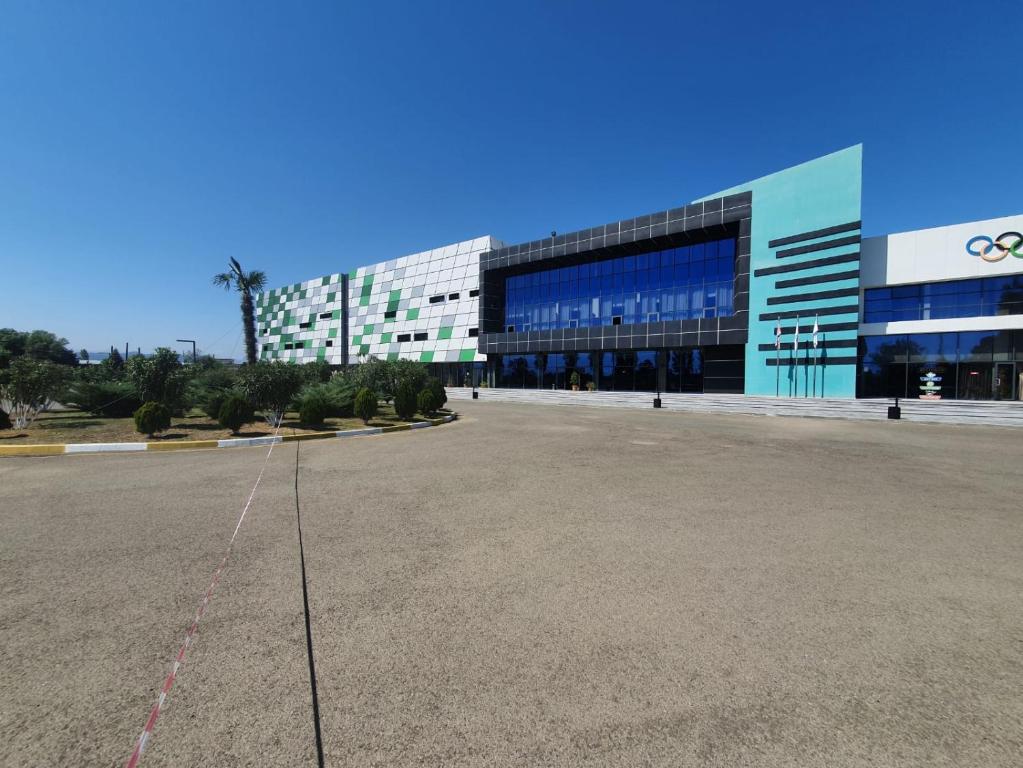an empty parking lot in front of a large building at Arena Hotel Lankaran in Lankaran