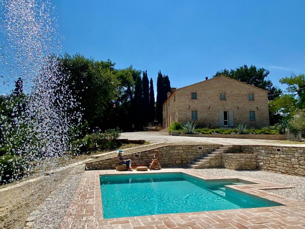 uma piscina no meio de um quintal com um edifício em Al Teatro di Tavignano em Cingoli