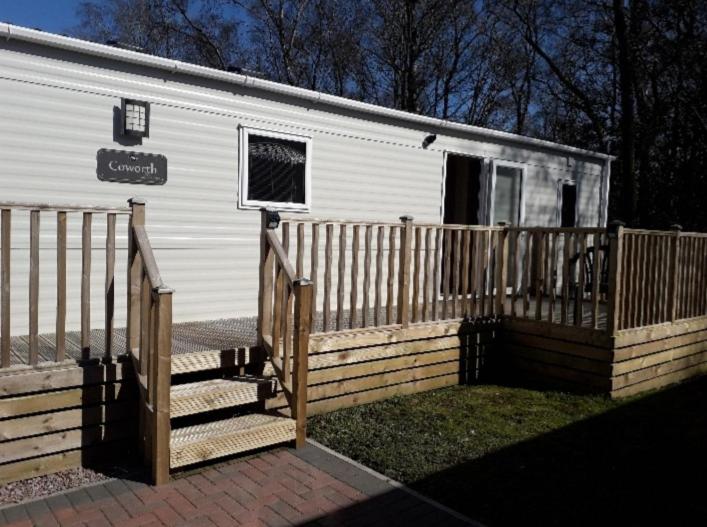a white trailer with a gate and a fence at Camelot Holiday Park, Longtown, Tranquility 21 Coworth in Carlisle