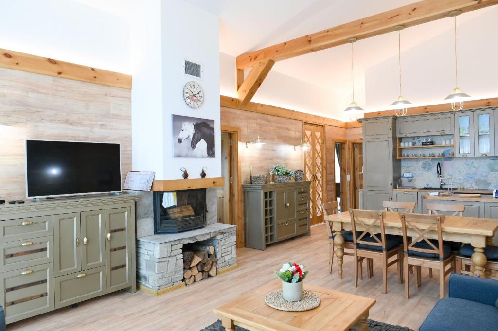 a kitchen and living room with a table and a fireplace at Villa Letizia near the Bansko Ski Resort in Razlog