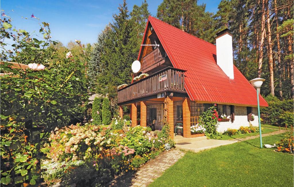 una casa con techo rojo en un jardín en Pod Czapla en Barczewo