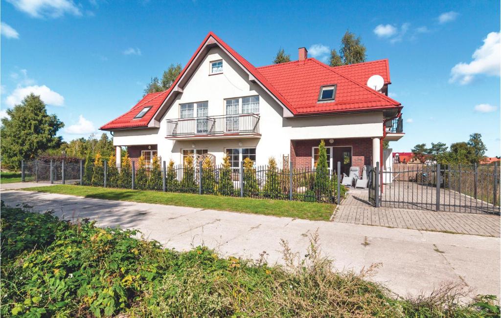 a white house with a red roof at Cozy Apartment In Rowy With Kitchen in Rowy