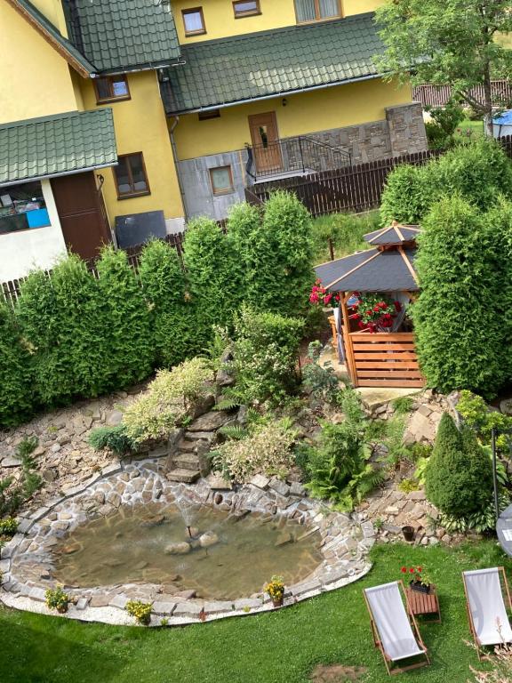 un jardin avec un étang en face d'une maison dans l'établissement willa anulka na Hrubym, à Zakopane
