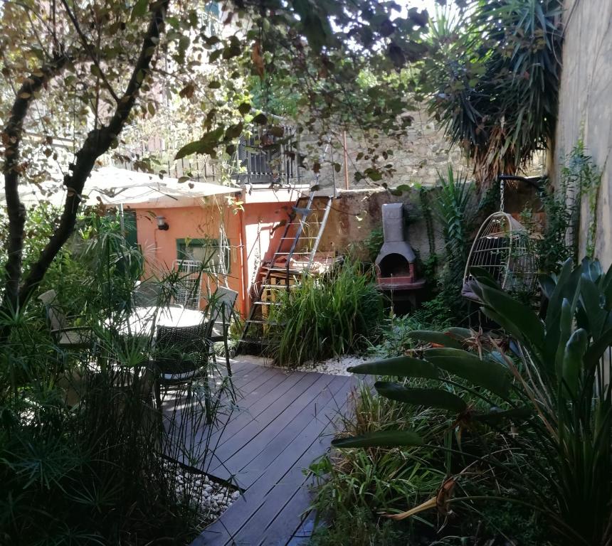 un jardín con una pasarela de madera y una casa en APPARTAMENTO CON GIARDINO, TERRAZZO e GARAGE A DUE PASSI DAL MARE e DALLE CINQUETERRE LT-0486, en Levanto
