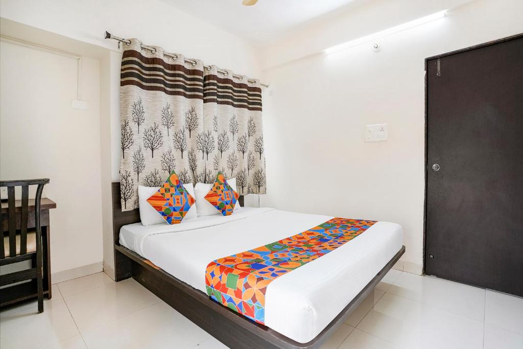 FabHotel Vardhan House II في Dāpuri: غرفة نوم بسرير في غرفة