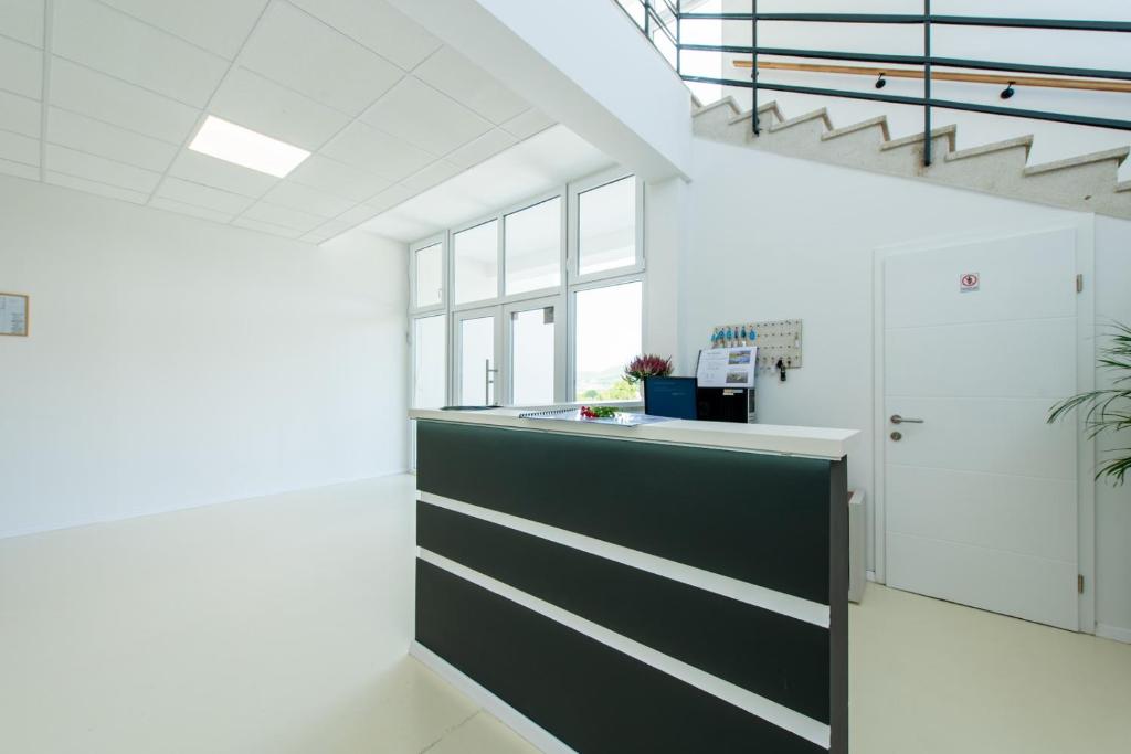 a kitchen with white walls and a black and white counter at Hostel Potpican in Potpićan