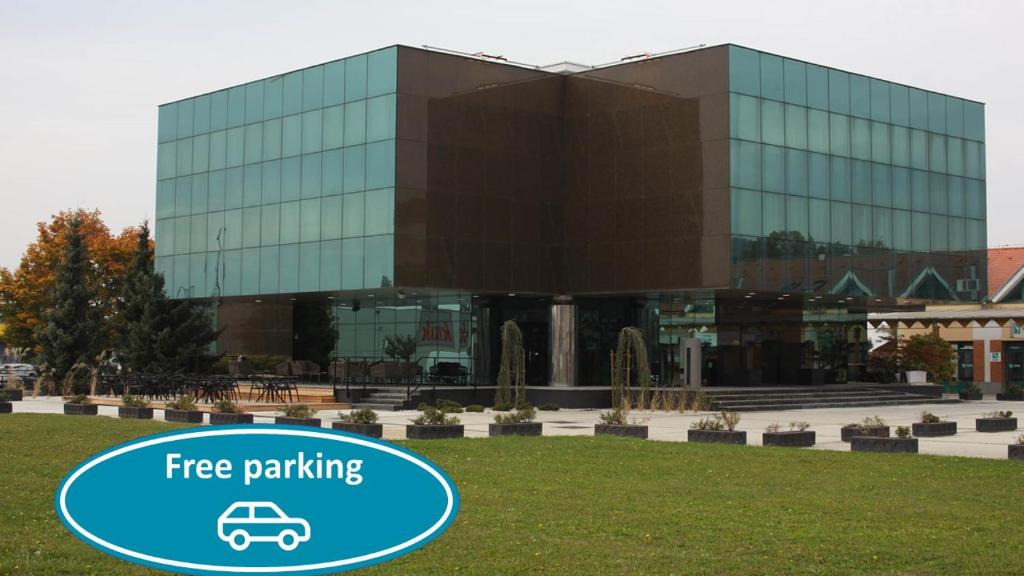 a building with a free parking sign in front of it at Hotel Cubis in Lendava