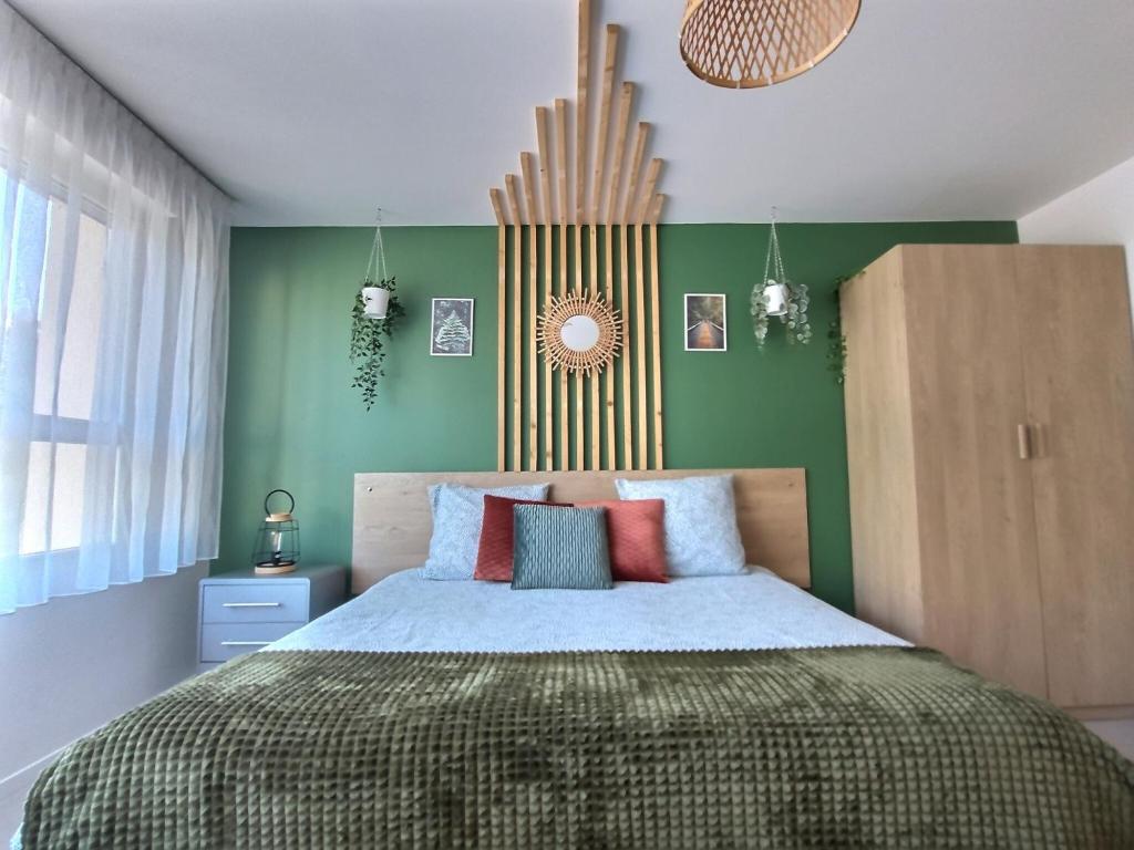um quarto com uma cama e uma parede verde em LE RIVIERA - Roissy CDG - Parc Astérix - Paris em Moussy-le-Neuf