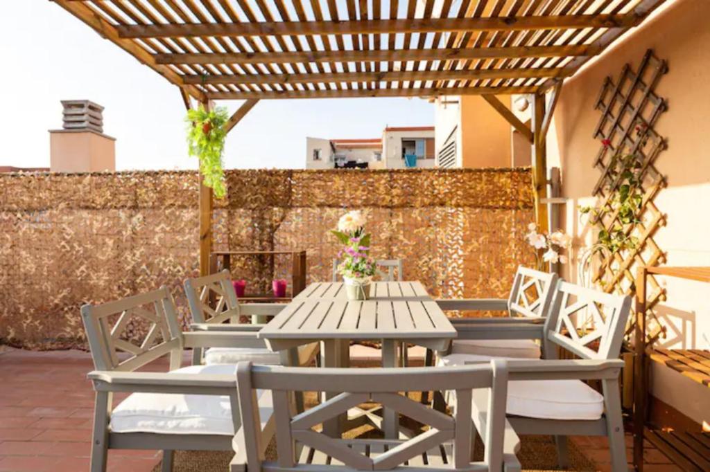 a wooden table and chairs on a patio at Apt.p/5 15min from Barcelona and Beaches W/Terrace in Sant Adria de Besos