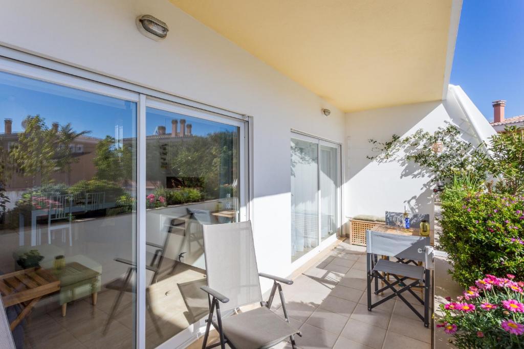 eine Terrasse mit Stühlen und einem Tisch auf dem Balkon in der Unterkunft Apartamento Terra Mare by Seewest in Lagos