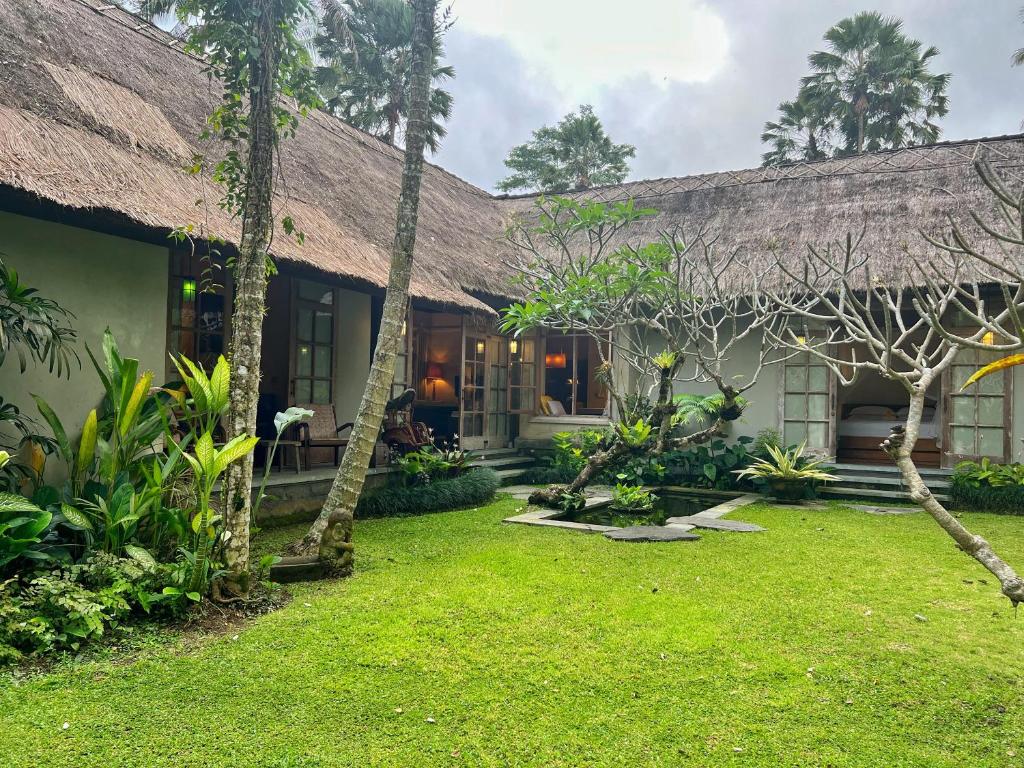 une maison avec une cour d'herbe devant elle dans l'établissement Desa Kerasan 5 -Luxury 2BRV 15 mins to Ubud, à Ubud