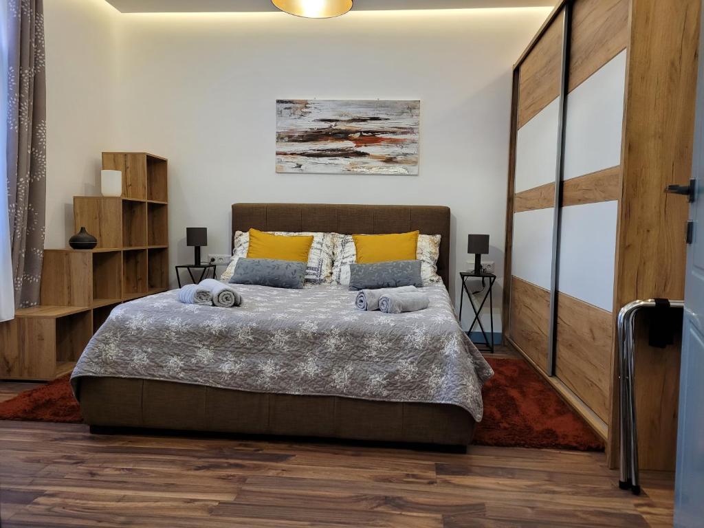 a bedroom with a large bed and wooden floors at Jégmadár Apartman in Debrecen