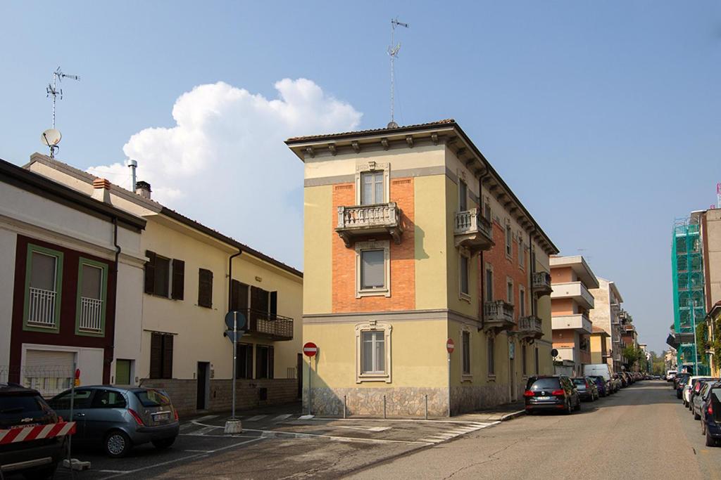 un bâtiment sur le côté d'une rue avec des voitures garées dans l'établissement Casa Luna, à Novara