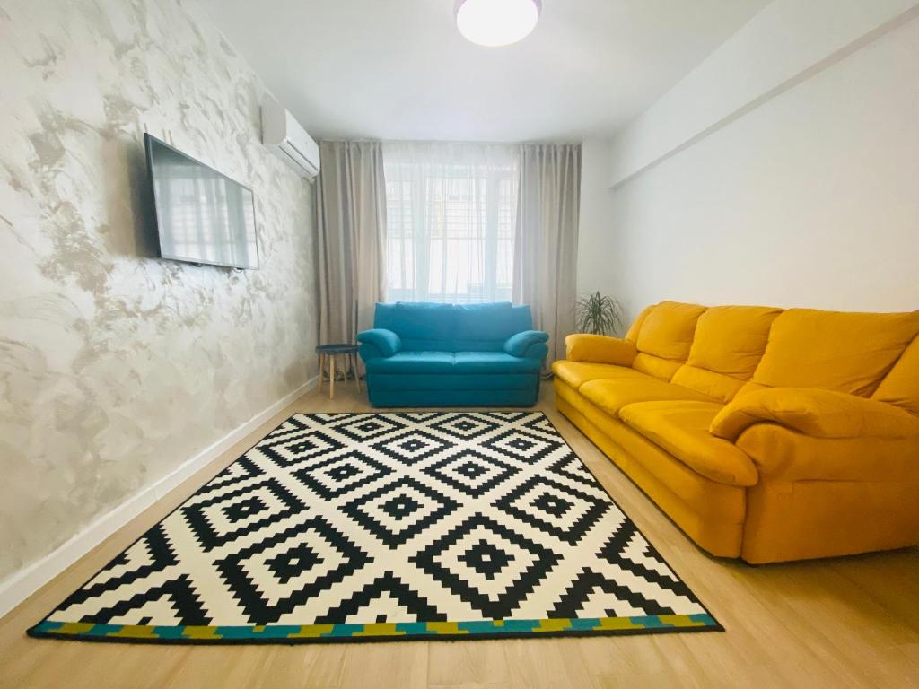 sala de estar con sofá amarillo y silla azul en Apartament Dorobanti en Bucarest