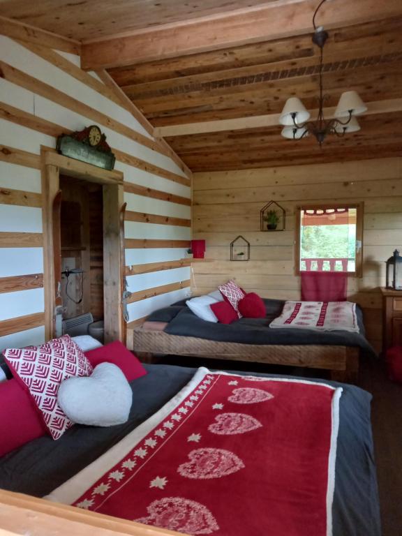 a bedroom with two beds in a log cabin at Chalet cocooning pleine nature in Montmorot