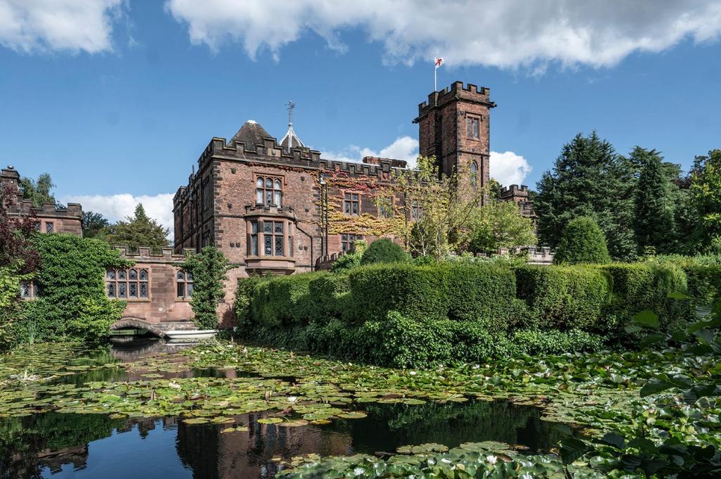 an old castle with a pond in front of it at New Hall Hotel & Spa, Birmingham in Birmingham