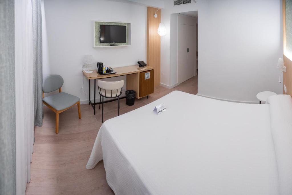 Postel nebo postele na pokoji v ubytování Sercotel Carlos III