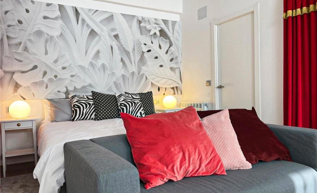 a bedroom with a bed with red and white pillows at Apartamento Grimaldi in Inogés