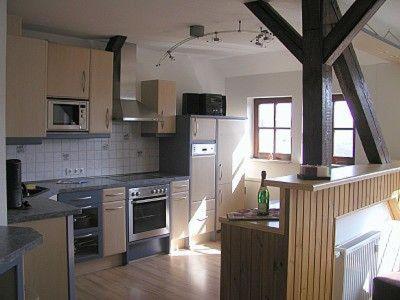 una grande cucina con elettrodomestici bianchi e pavimenti in legno di Ferienperle-Erzgebirge a Schwarzenberg/Erzgebirge