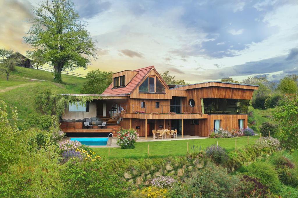 a large wooden house with a swimming pool at Schmolti's Chalet - Wellness über Graz in Zösenberg