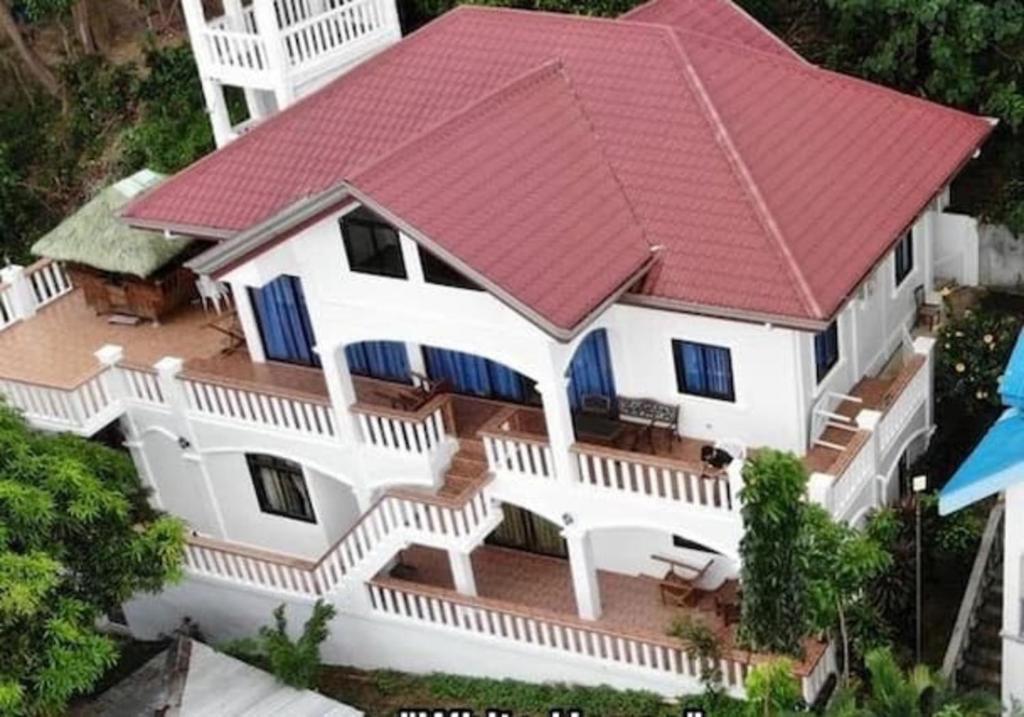 uma vista superior de uma casa branca com um telhado vermelho em Charming 6-Bed House in Puerto Galera em Puerto Galera
