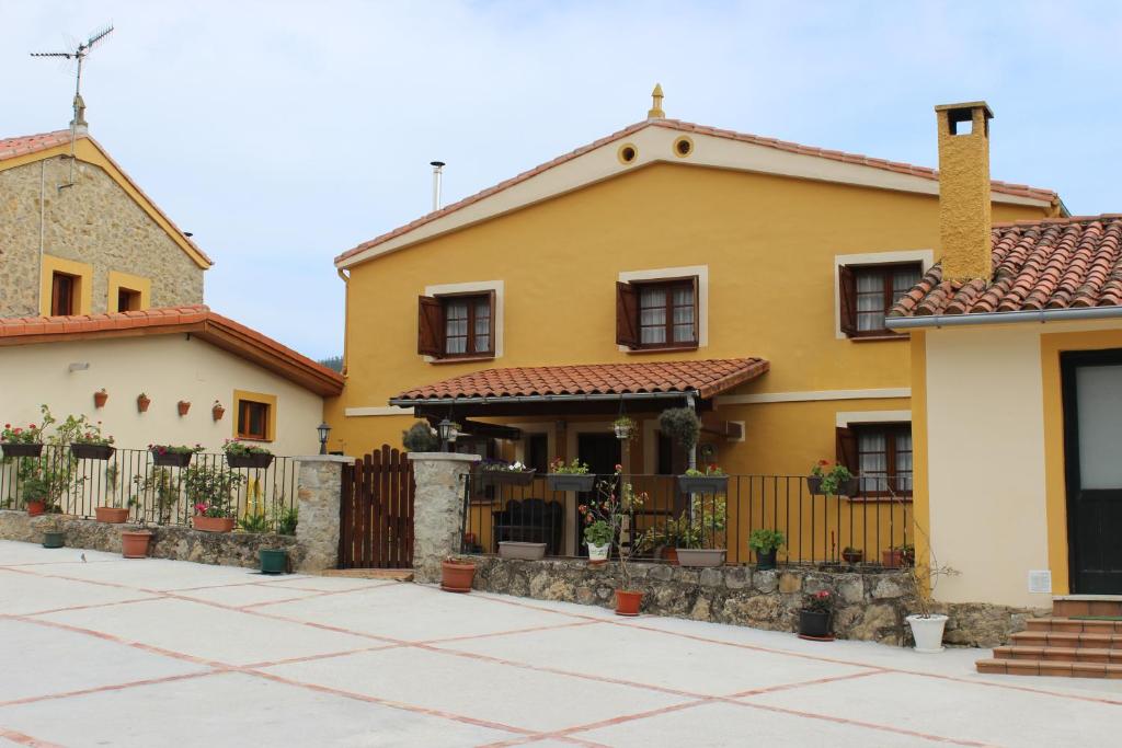 una casa amarilla con una valla delante de ella en Cerezal 1, casa en plena naturaleza 