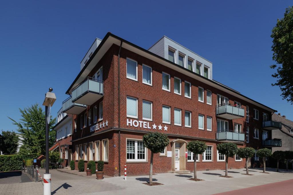 a large red brick hotel building on a street at Hotel Jellentrup in Münster